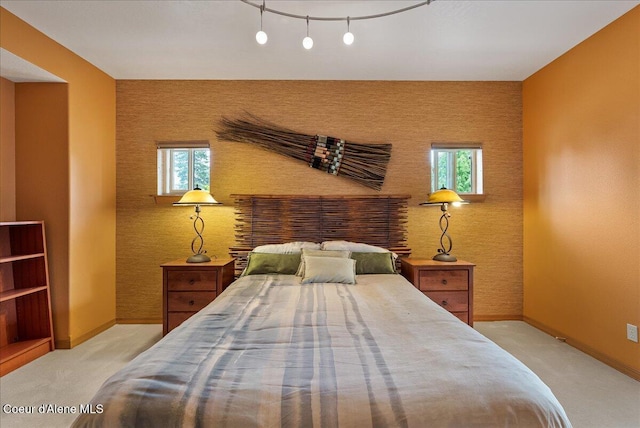 1010 E Mullan Ave Unit 202, Coeur Dalene, ID 83814 - carpeted bedroom featuring baseboards, multiple windows, an accent wall, and wallpapered walls
