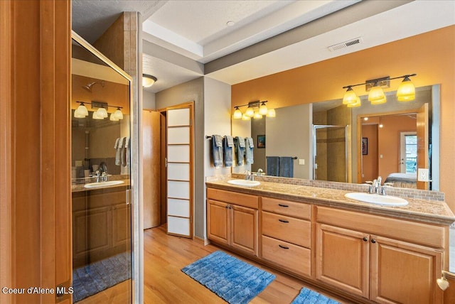 1010 E Mullan Ave Unit 202, Coeur Dalene, ID 83814 - full bathroom featuring wood finished floors, double vanity, a stall shower, and connected bathroom