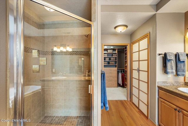 1010 E Mullan Ave Unit 202, Coeur Dalene, ID 83814 - full bathroom with a shower stall, vanity, wood finished floors, and a spacious closet
