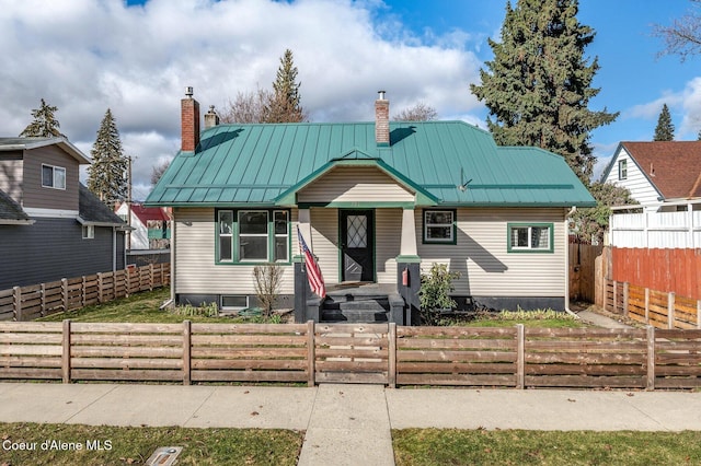 721 N A St, Coeur Dalene, ID 83814 - view of front of house with a chimney, a standing seam roof, metal roof, and a fenced front yard