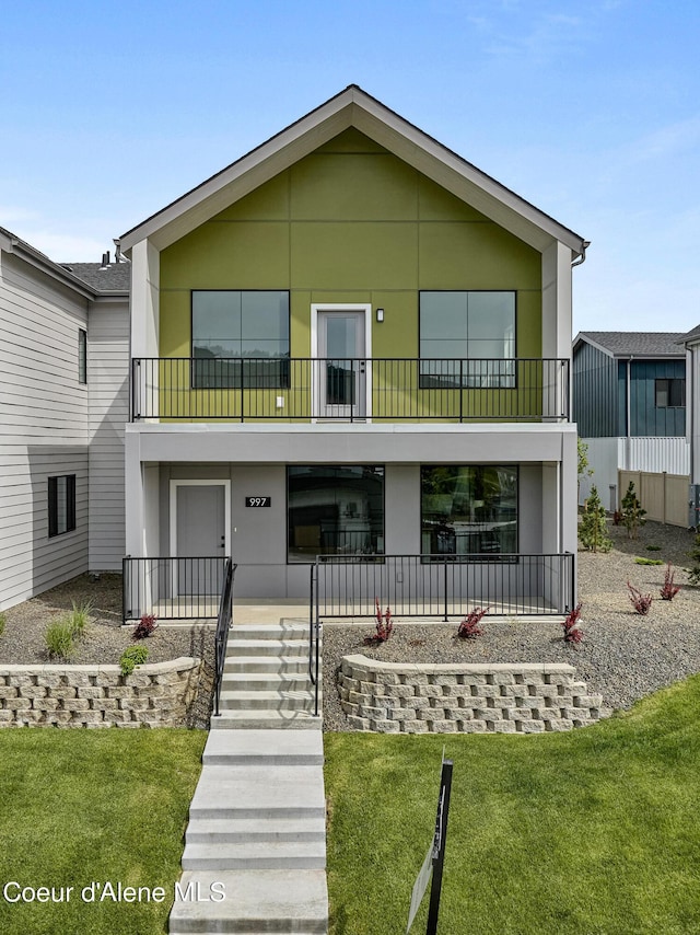 997 E Railroad Ave, Post Falls, ID 83854 - view of front of house with a balcony, a front lawn, covered porch, and stucco siding