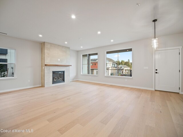 997 E Railroad Ave, Post Falls, ID 83854 - unfurnished living room featuring light wood-style flooring, a tiled fireplace, recessed lighting, and baseboards