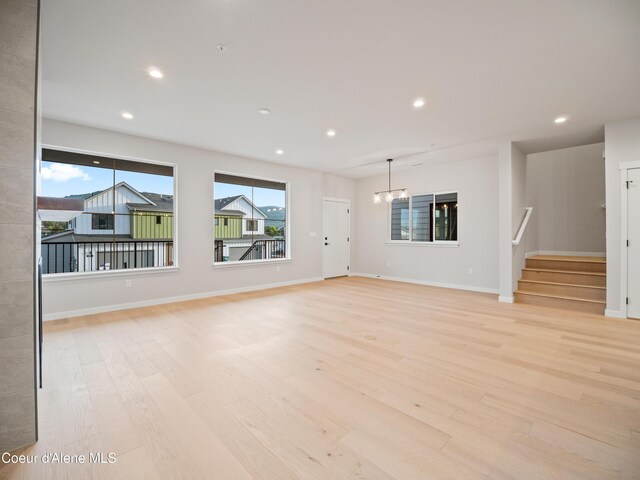 997 E Railroad Ave, Post Falls, ID 83854 - unfurnished living room with light wood-type flooring, stairs, baseboards, and recessed lighting