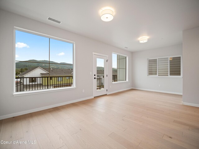 997 E Railroad Ave, Post Falls, ID 83854 - empty room featuring light wood finished floors, baseboards, and a mountain view