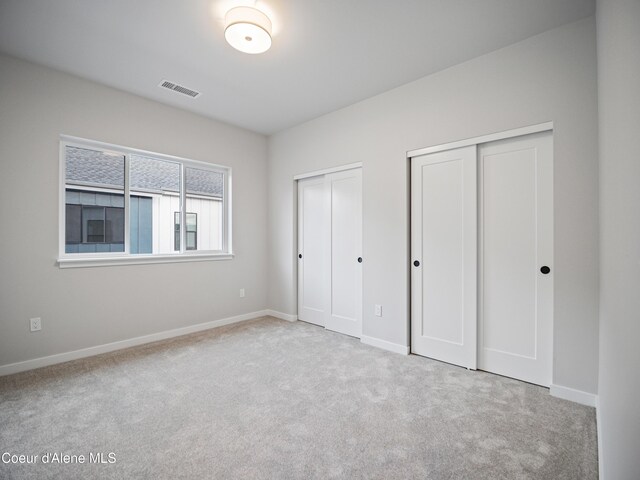 997 E Railroad Ave, Post Falls, ID 83854 - unfurnished bedroom featuring multiple closets, carpet flooring, and baseboards