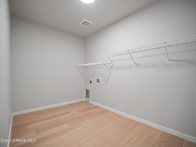 997 E Railroad Ave, Post Falls, ID 83854 - laundry area with light wood finished floors, hookup for a washing machine, hookup for an electric dryer, and baseboards