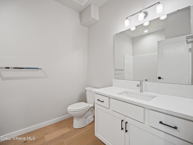 997 E Railroad Ave, Post Falls, ID 83854 - bathroom featuring vanity, toilet, wood finished floors, and baseboards