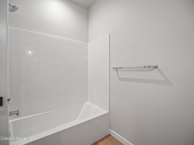 997 E Railroad Ave, Post Falls, ID 83854 - bathroom featuring baseboards, wood finished floors, and bathing tub / shower combination