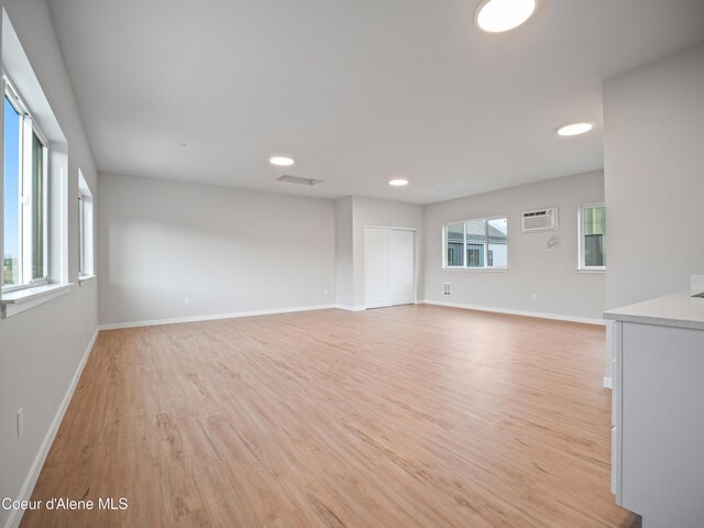 997 E Railroad Ave, Post Falls, ID 83854 - unfurnished room with light wood finished floors, baseboards, an AC wall unit, and recessed lighting