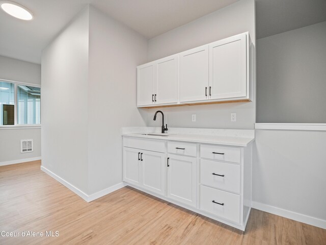 997 E Railroad Ave, Post Falls, ID 83854 - bar with a sink, light wood-style flooring, and baseboards