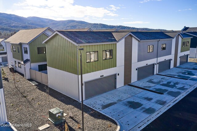 997 E Railroad Ave, Post Falls, ID 83854 - view of side of home featuring a mountain view, a shingled roof, and an attached garage