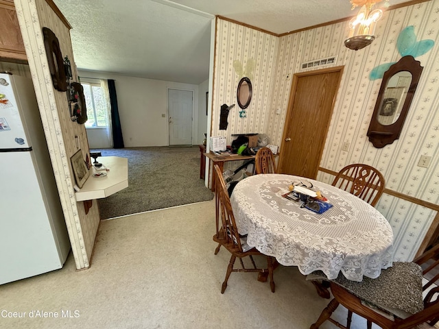 1068 Moon Gulch Rd, Kellogg, ID 83837 - dining room featuring carpet, wallpapered walls, a textured ceiling, and crown molding