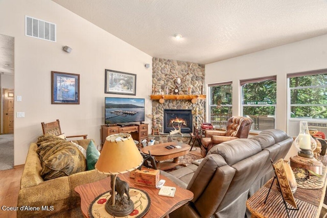 17461 N Right Fork Rd, Hauser, ID 83854 - living area with lofted ceiling, wood finished floors, a textured ceiling, and a fireplace