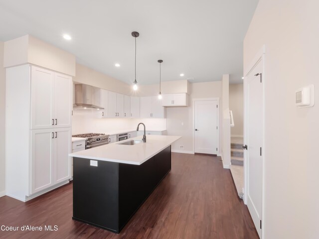 1008 E 4th Ave # 104, Post Falls, ID 83854 - kitchen featuring wall chimney range hood, a sink, high end stove, white cabinetry, and light countertops