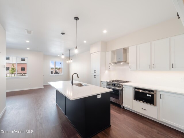 1008 E 4th Ave # 104, Post Falls, ID 83854 - kitchen featuring wall chimney exhaust hood, high end range, a sink, dark wood finished floors, and recessed lighting
