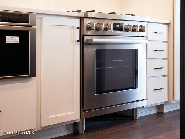1008 E 4th Ave # 104, Post Falls, ID 83854 - kitchen view of appliances with stainless steel finishes, white cabinets, and dark wood-style flooring
