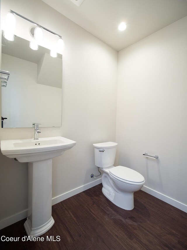 1008 E 4th Ave # 104, Post Falls, ID 83854 - bathroom with wood finished floors, toilet, baseboards, a sink, and recessed lighting