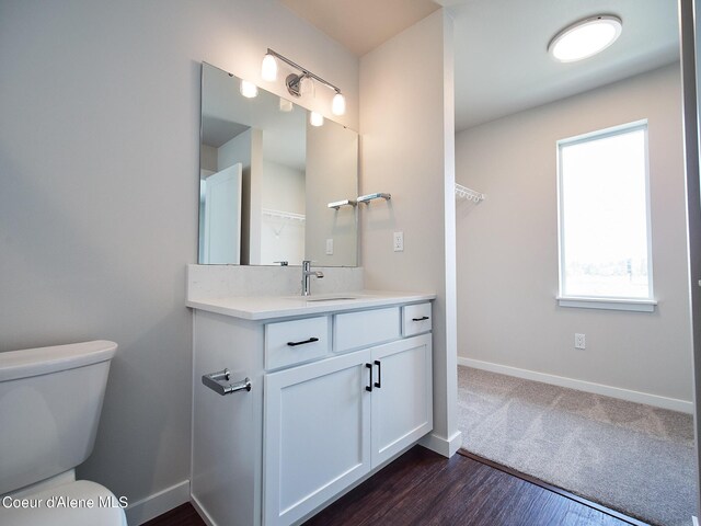 1008 E 4th Ave # 104, Post Falls, ID 83854 - bathroom with vanity, toilet, baseboards, and wood finished floors