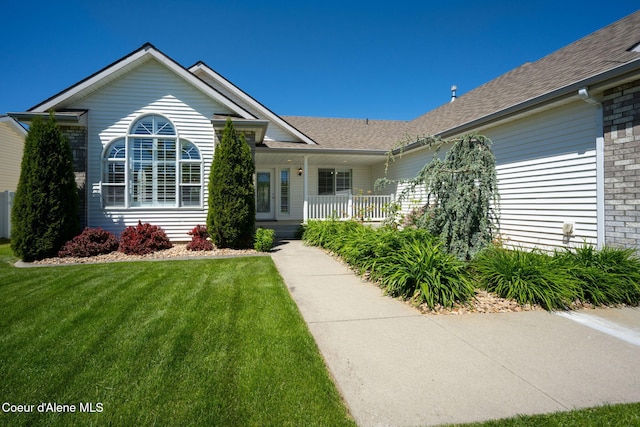 2619 N Tiatan St, Post Falls, ID 83854 - view of front of property with a front lawn, covered porch, roof with shingles, and brick siding