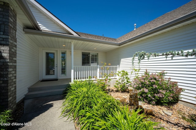 2619 N Tiatan St, Post Falls, ID 83854 - entrance to property featuring a porch, roof with shingles, and brick siding