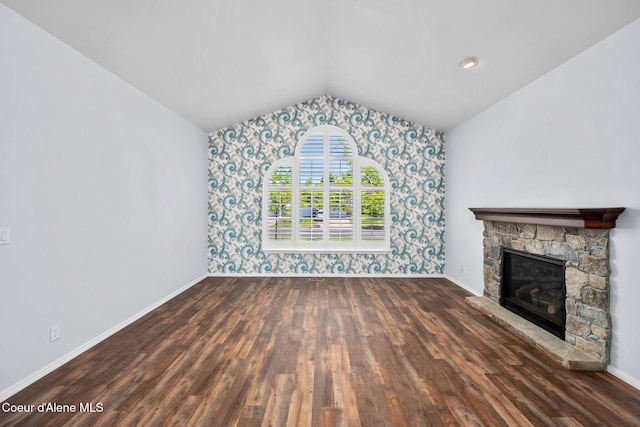 2619 N Tiatan St, Post Falls, ID 83854 - unfurnished living room featuring lofted ceiling, wallpapered walls, wood finished floors, baseboards, and a stone fireplace
