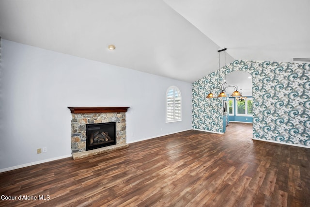 2619 N Tiatan St, Post Falls, ID 83854 - unfurnished living room with wood finished floors, baseboards, a stone fireplace, and high vaulted ceiling