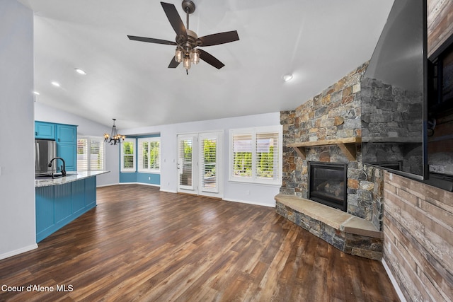 2619 N Tiatan St, Post Falls, ID 83854 - unfurnished living room featuring vaulted ceiling, a fireplace, a chandelier, dark wood-style flooring, and a ceiling fan