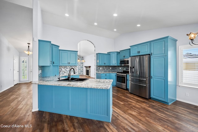 2619 N Tiatan St, Post Falls, ID 83854 - kitchen featuring stainless steel appliances, blue cabinetry, a peninsula, a sink, and backsplash