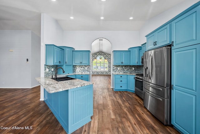 2619 N Tiatan St, Post Falls, ID 83854 - kitchen featuring appliances with stainless steel finishes, a peninsula, a sink, blue cabinetry, and backsplash