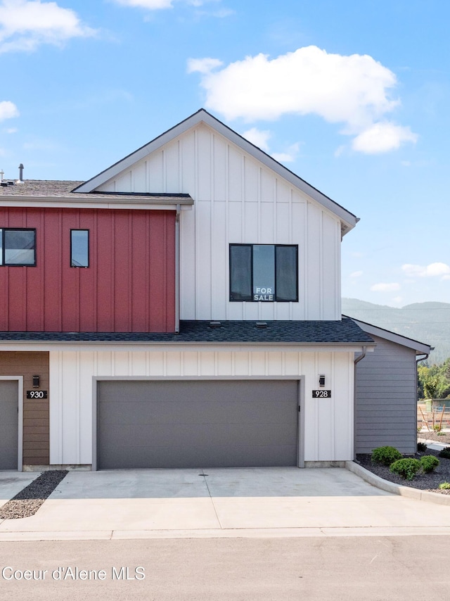 928 E Railroad Ave, Post Falls, ID 83854 - view of front of home with board and batten siding, driveway, an attached garage, and roof with shingles