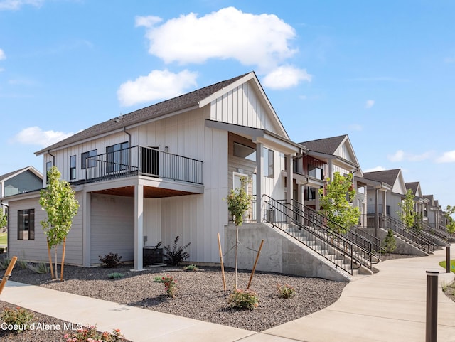 928 E Railroad Ave, Post Falls, ID 83854 - view of front of home with a balcony, board and batten siding, a residential view, and roof with shingles