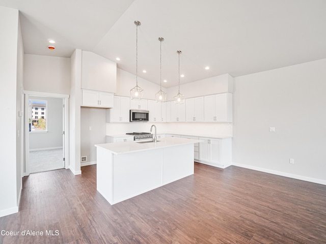 928 E Railroad Ave, Post Falls, ID 83854 - kitchen featuring appliances with stainless steel finishes, an island with sink, light countertops, white cabinetry, and high vaulted ceiling