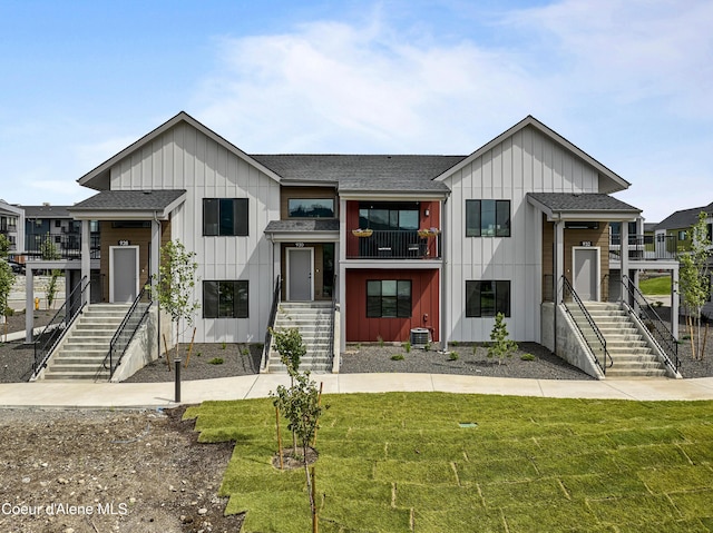 928 E Railroad Ave, Post Falls, ID 83854 - view of front facade featuring board and batten siding, stairs, a balcony, a front lawn, and roof with shingles