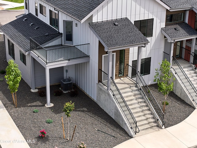 928 E Railroad Ave, Post Falls, ID 83854 - view of property exterior featuring roof with shingles, board and batten siding, stairway, central AC, and a balcony