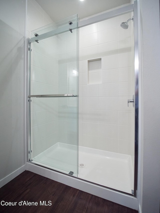 928 E Railroad Ave, Post Falls, ID 83854 - bathroom featuring a stall shower, wood finished floors, and baseboards
