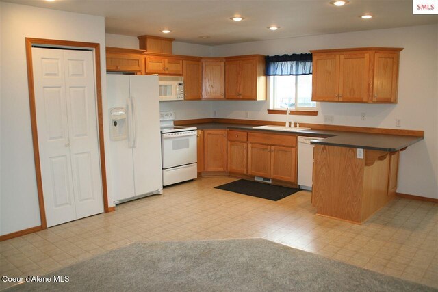 1601 Sequoia St, Sandpoint, ID 83864 - kitchen featuring white appliances, a sink, a peninsula, dark countertops, and recessed lighting