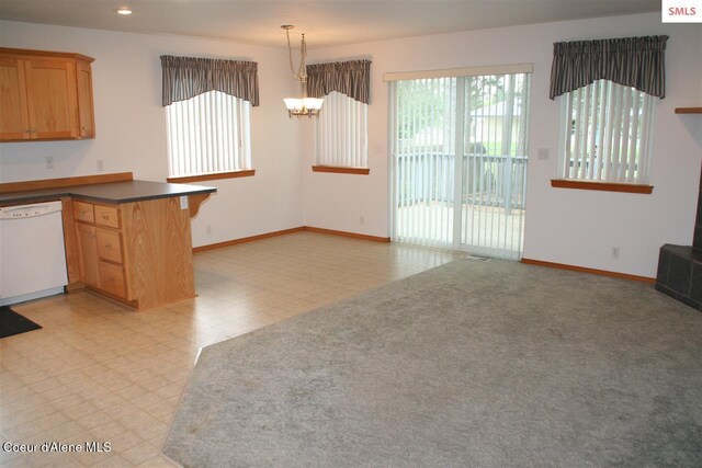 1601 Sequoia St, Sandpoint, ID 83864 - kitchen with white dishwasher, a peninsula, baseboards, light flooring, and a chandelier