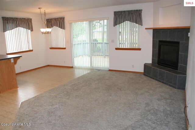 1601 Sequoia St, Sandpoint, ID 83864 - unfurnished living room with baseboards, a fireplace, tile patterned floors, and a chandelier