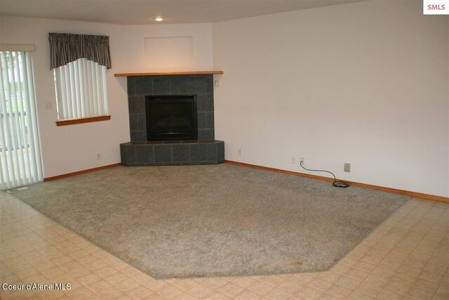 1601 Sequoia St, Sandpoint, ID 83864 - unfurnished living room featuring carpet floors, baseboards, and a tiled fireplace