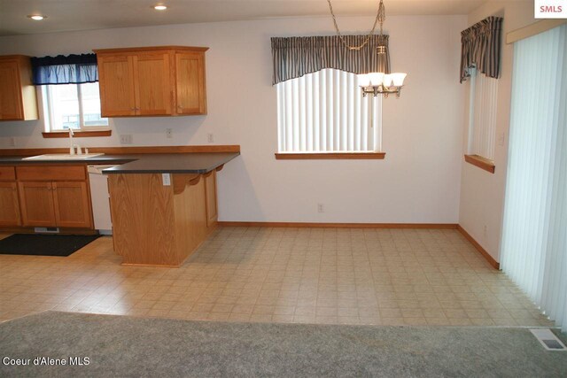 1601 Sequoia St, Sandpoint, ID 83864 - kitchen with a sink, white dishwasher, a chandelier, dark countertops, and a peninsula