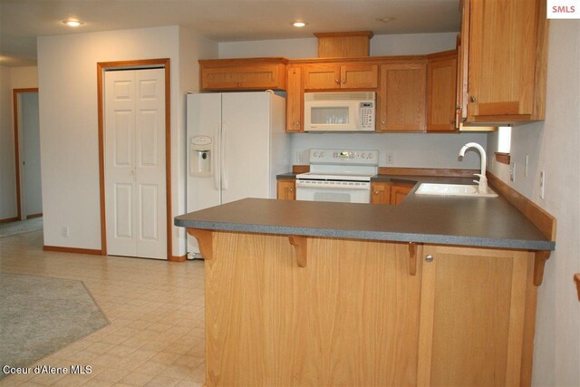1601 Sequoia St, Sandpoint, ID 83864 - kitchen featuring white appliances, a sink, a peninsula, light flooring, and a kitchen breakfast bar