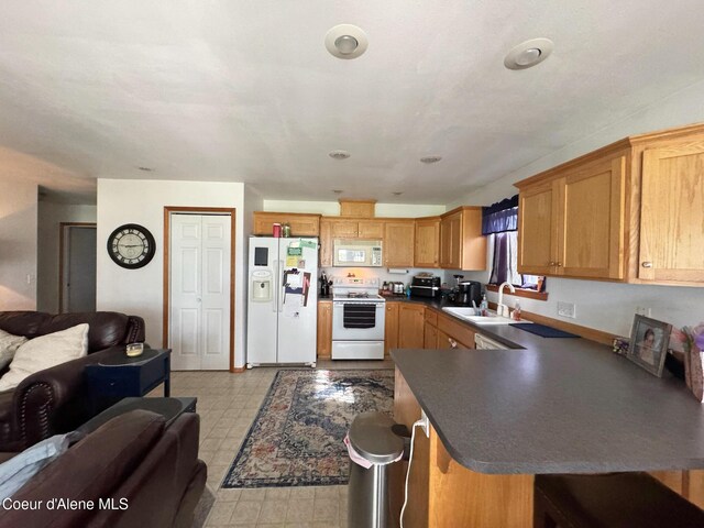 1601 Sequoia St, Sandpoint, ID 83864 - kitchen with white appliances, a sink, open floor plan, dark countertops, and light flooring