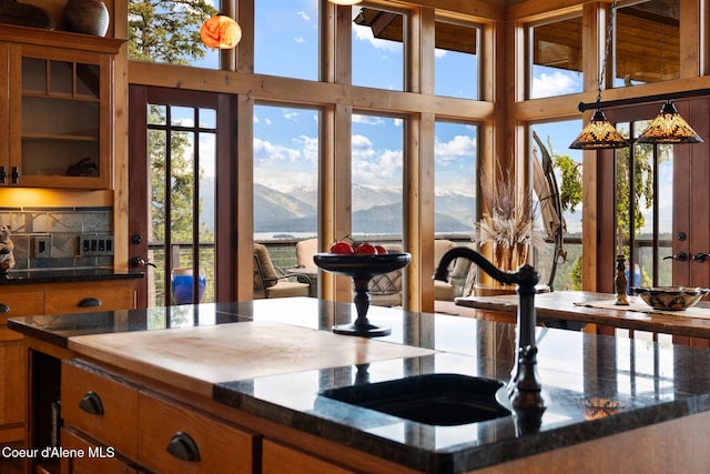 295 Sky Meadow Ln, Sagle, ID 83860 - kitchen with a mountain view, brown cabinets, a towering ceiling, glass insert cabinets, and a sink