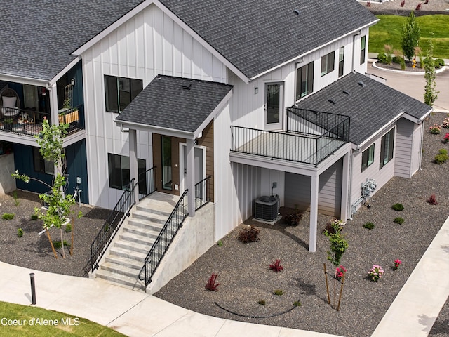 998 E Railroad Ave, Post Falls, ID 83854 - view of front of house with a balcony, a shingled roof, board and batten siding, and cooling unit