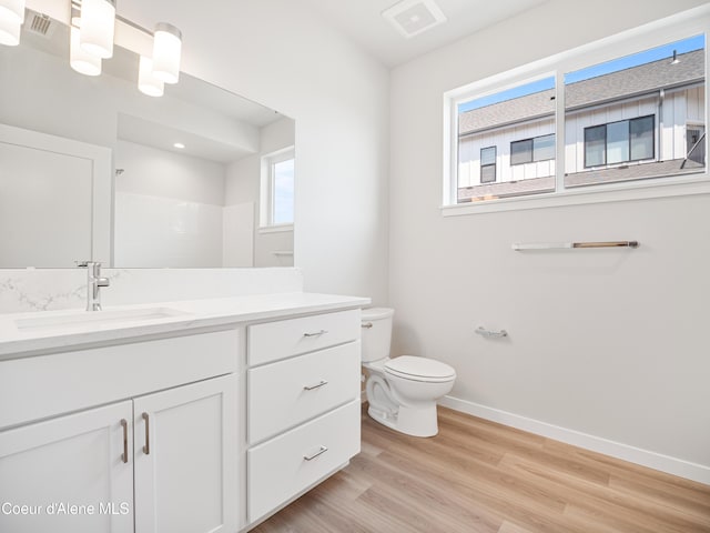 998 E Railroad Ave, Post Falls, ID 83854 - full bathroom with toilet, vanity, baseboards, wood finished floors, and a shower
