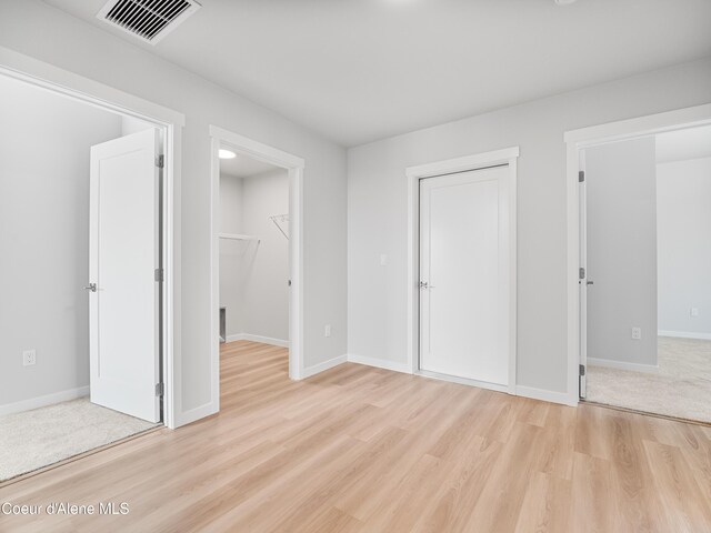 998 E Railroad Ave, Post Falls, ID 83854 - unfurnished bedroom with light wood-type flooring, a closet, baseboards, and a spacious closet