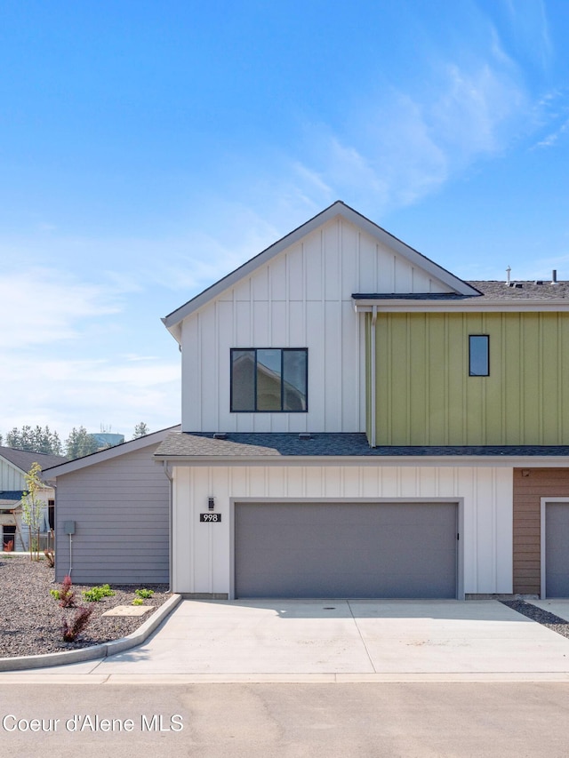 998 E Railroad Ave, Post Falls, ID 83854 - view of front of home with board and batten siding, a garage, driveway, and roof with shingles