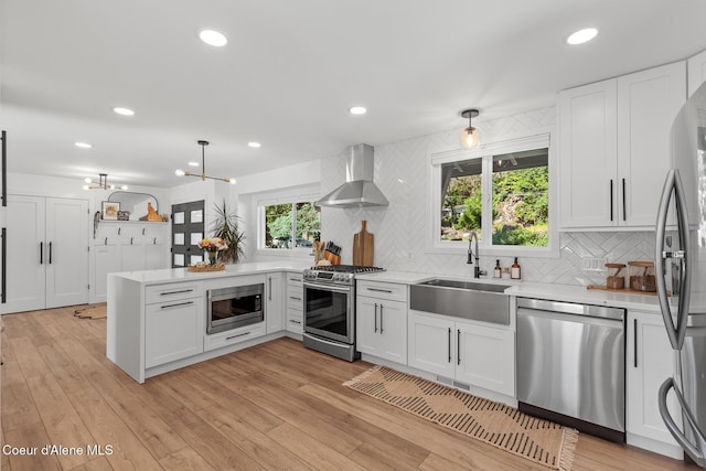 1113 N Lambert Ln, Coeur Dalene, ID 83814 - kitchen featuring stainless steel appliances, wall chimney range hood, a sink, light countertops, and decorative backsplash