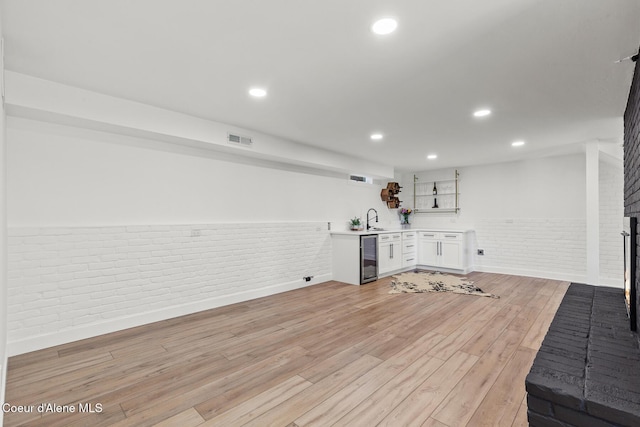 1113 N Lambert Ln, Coeur Dalene, ID 83814 - miscellaneous room featuring brick wall, a sink, light wood-style floors, a brick fireplace, and wainscoting