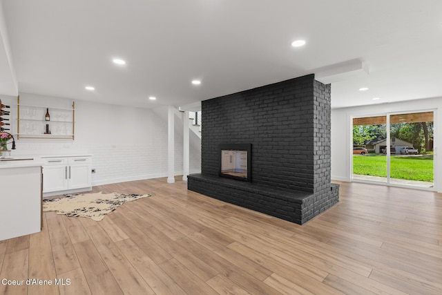 1113 N Lambert Ln, Coeur Dalene, ID 83814 - unfurnished living room with light wood-style floors, a fireplace, recessed lighting, and a sink